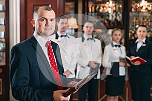 The interaction of the staff. Hotel or restaurant manager and his staff in kitchen. interacting to head chef in