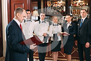 The interaction of the staff. Hotel or restaurant manager and his staff in kitchen. interacting to head chef in