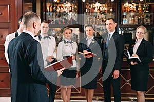 The interaction of the staff. Hotel or restaurant manager and his staff in kitchen. interacting to head chef in