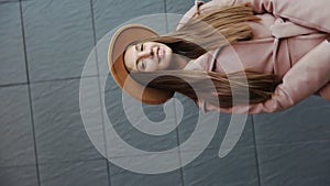 Interception portrait of Charming long hair young woman in a coat and round hat