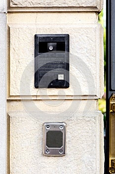 An intercom with a call button and a camera.