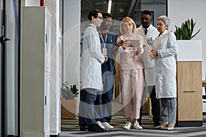 Intercultural doctors and assistants discussing medical data on tablet screen