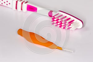 Interdental brush against the usual toothbrush, closeup in selective focus