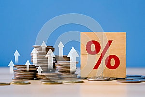 Interest rate,Financial and dividend concept.Wooden block with percentage sign and up arrow.Tax,financial growth, increase,