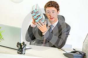 Interested businessman shaking present box