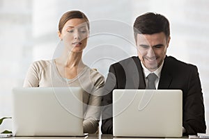 Interested curious businesswoman looking at businessman laptop s