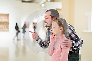 interested father and daughter exploring expositions in museum