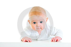 Interested four month old baby laying on abdomen