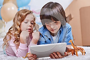 Interested kids using tablet in children room