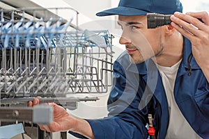 Interested man looking at kitchen appliance