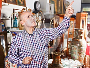 Man pointing at goods at antiques shop