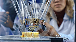 Researchers watching 3-D printing machine in process