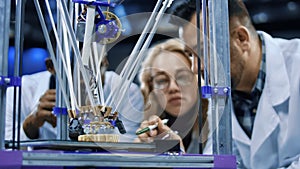 Researchers watching 3-D printing machine in process