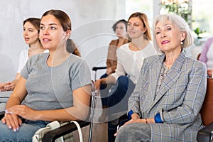 Interested senior woman listening to lecture with group of women