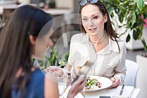 Interested woman tasting salad in cafe