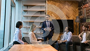 Interested group of colleagues listen to speaker presenting new idea