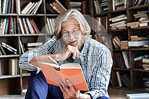 Interested young male student glasses enjoy interesting book library