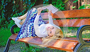 Interesting book. Smart and pretty. Smart lady relaxing. Girl lay bench park relaxing with book, green nature background