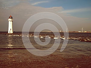 Interesting lighthouse in the sea from nice background, sky blue from clouds, sunset