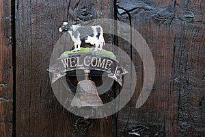 An interesting and nice doorbell on a farmhouse with a cow