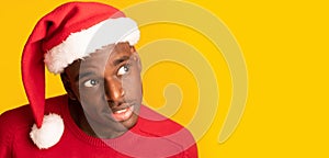 Interesting Offer. Curious African Guy In Santa Hat Overhear On Yellow Background