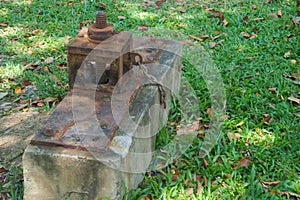 An interesting, old and rustic water gateway that allows the flow or damming of water to and from a large lush Thai park lake.