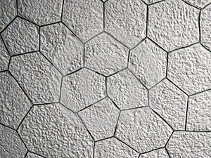 Interesting pattern of hexagonal shaped white bricks on the wall or floor, made of rock stone and a modern wallpaper background