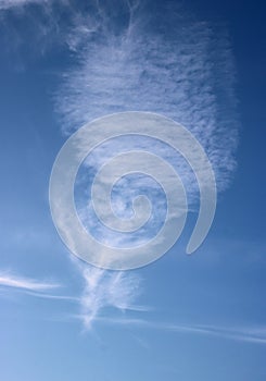 Interesting white feathery cloud in blue sky