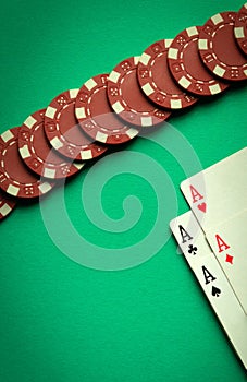 An interesting poker game with a winning combination of four of a kind or quads. Playing cards and red chips on a green table in a photo