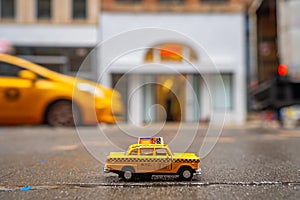 Interesting shot of an old yellow taxi toy in New York City, USA