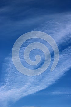 Interesting white feathery cloud in blue sky