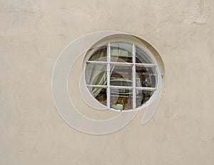 Interestingly round window in the wall of the building, the wind