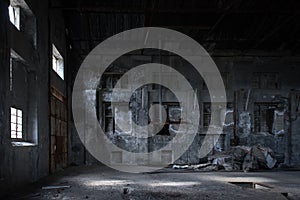 Interior of abandoned factory with stained concrete walls, bricked windows and pieces of old equipment