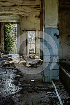 Interior of an abandoned and half-ruined building with dilapidated wooden doors and windows that open onto