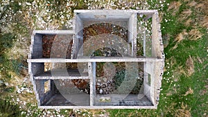 Interior of abandoned stone house without roof, aerial view directly above