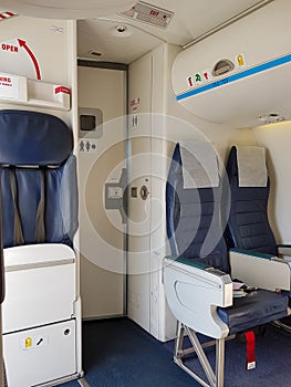 interior of aircraft, flight attendant jump seat and two passengers seats in cabin