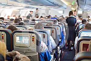 Interior of airplane with passengers on seats.