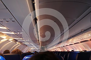 Interior of airplane with passengers on seats waiting to taik of