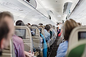 Interior of airplane with passengers on seats waiting to taik off.