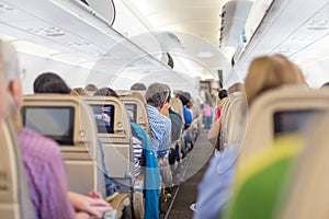 Interior of airplane with passengers on seats waiting to taik off.