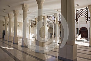 Interior of Al Hussein Bin Ali Mosque in Aqaba, Jordan. White marble colonnade of masjid.