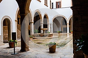 Interior of the Almudaina Palace in Spain. White arched walls surrounding the hall