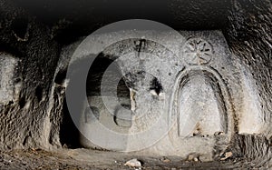 Interior of ancient cave christian temple with image of cross cut on the wall, Soganli ,Cappadocia, Turkey