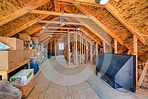 Interior of the attic of house with boxes and old appliances under gable roof