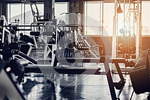 Interior background of room in gym or fitness center fully equip of bodybuilding equipments and machines