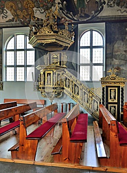 The interior of baroque church in Stegna Poland with ornamental wooden golden pulpit.