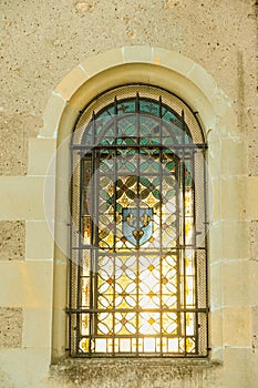 Interior, barred, chapel window with morning light