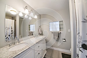 Interior of a bathroom with double vanity sink and a window with glass cube panel