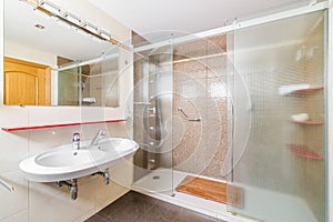 Interior of a bathroom in light tones with spacious shower