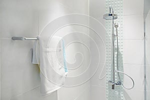 Interior of bathroom with modern shower head and white towel